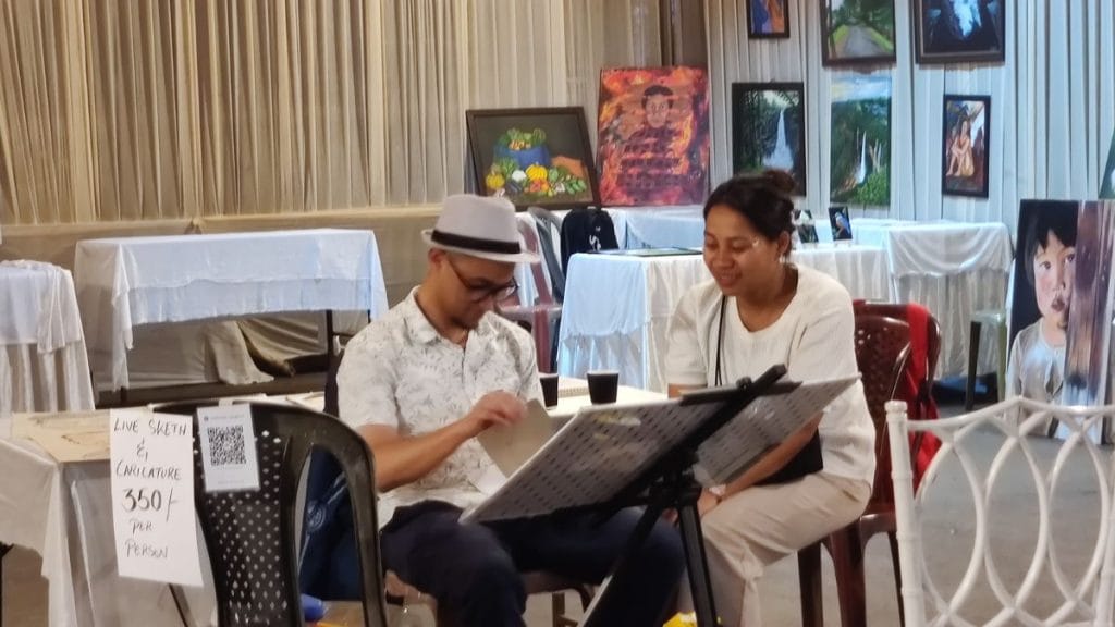 Deaf-mute caricature artist Dashan Lyngkhoi painting a portrait of a visitor | Stela Dey, ThePrint