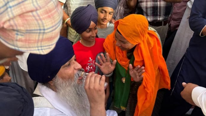 Forty-three-year-old Gurjeet SIngh Khalsa drinks water after coming down from the BSNL tower | Anushka Srivastava, ThePrint