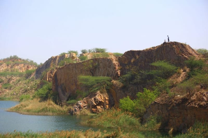 एडवेंचर पसंद करने वाले विज़िटर्स साफ-सुथरी पनिकोट झील के ऊपर चट्टानों पर चढ़ते हैं | फोटो: मनीषा मोंडल/दिप्रिंट