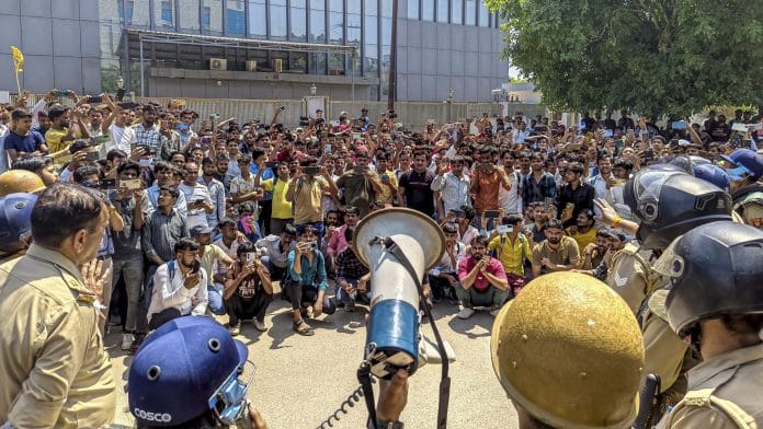 Factory workers during a protest demanding a hike in wages, in Noida, Gautam Buddh Nagar district, Uttar Pradesh, Monday, April 13, 2026. The protest carried incidents of arson, vandalism and stone-pelting reported from Phase-2 and Sector 60 areas, police said. | PTI Photo