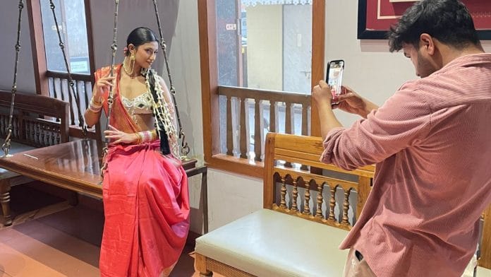 A young content creator, Pratibha Sahu, poses for a “concept shoot” for her Instagram account page, at a restaurant in Raipur. Sabah Gurmat | ThePrint