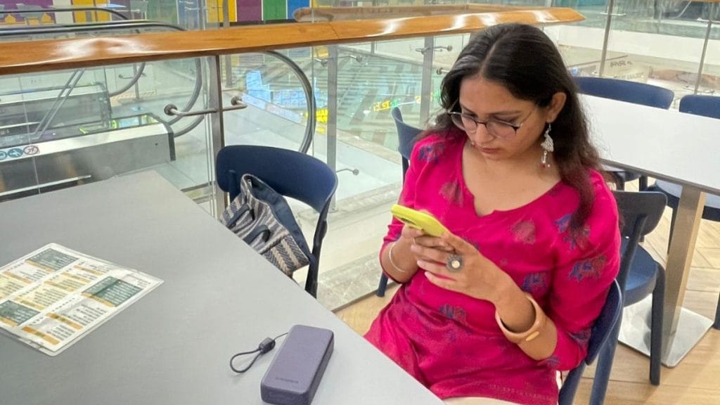 Bhopal based food vlogger and Reel-maker Kawalpreet Kaur Kalsi sits in the food court of a mall as she opens up her phone to show her screen time. Sabah Gurmat | ThePrint