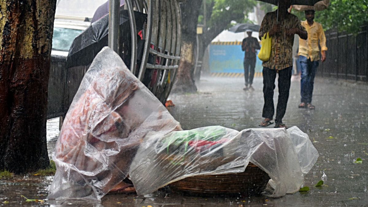 A street vendor in Mumbai covers herself with plastic to protect herself from the rain | Photo: ANI/File