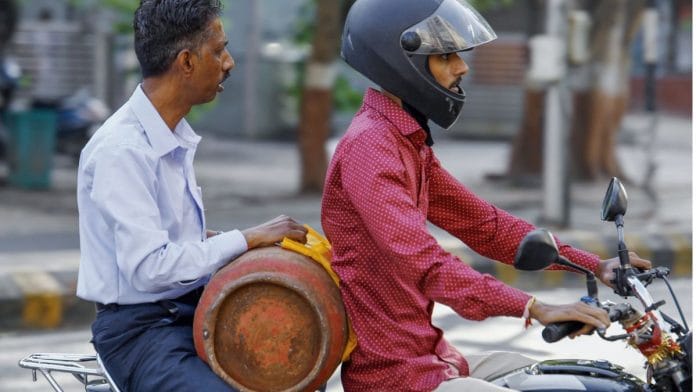 A man carries his empty LPG cylinder on bike as he arrives at the LPG depot, amid reports of a nationwide shortage, in Ahmedabad on Wednesday. | ANI