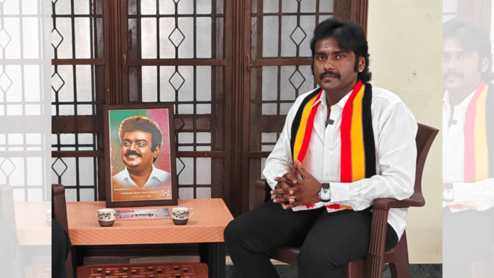 DMDk leader V. Prabhakaran, with his father Vijayakanth's portrait, in a conversation with ThePrint at his Virudhunagar house.