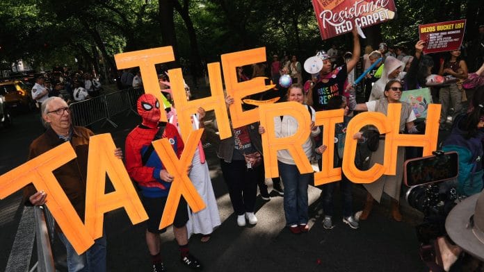 Demonstrators participate in a “Resistance Red Carpet” protest against the Met Gala, the star-studded fundraiser known for its extravagant fashion and high-profile guests, in New York City, U.S., May 4, 2026. | REUTERS/Bing Guan