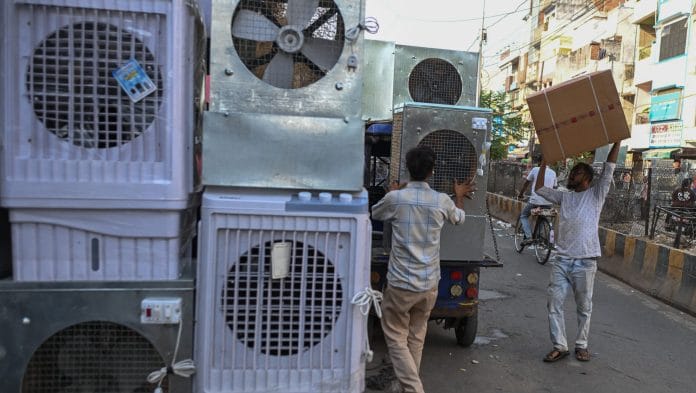 Workers unload air coolers from a delivery truck during a heat wave in Allahabad, India | Bloomberg