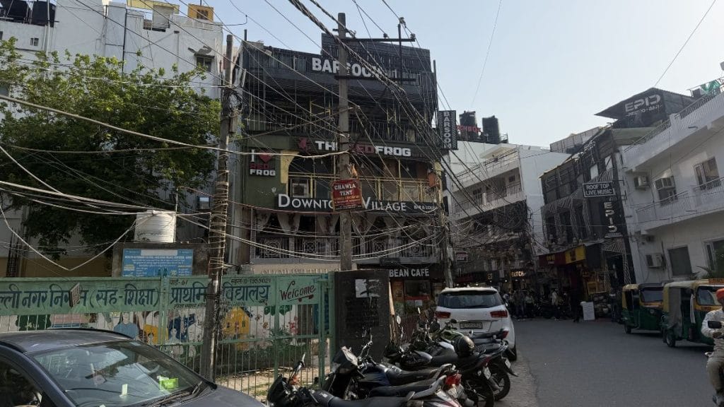 Tangled electric wires crisscross overhead, mixed with decorative lighting stretched between rows of restaurants and bars. Triya Gulati | ThePrint