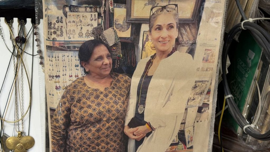 Dust hangs over photographs of Kusum Jain with Dimple Kapadia at her store in HKV. Triya Gulati | ThePrint