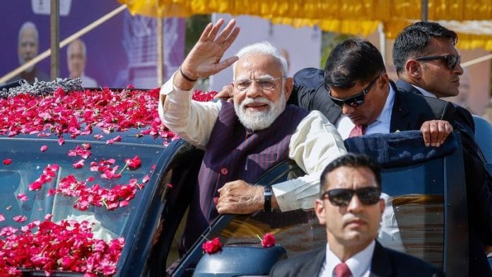 Prime Minister Narendra Modi waves during a roadshow | Photo: Reuters
