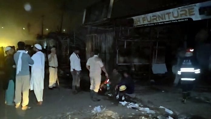 Police personnel and people gather after a fire broke out at a furniture market, in Shastri Park, New Delhi, Saturday, May 23, 2026. (PTI Photo)