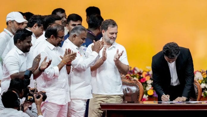 Newly-elected Tamil Nadu Chief Minister and TVK chief C Joseph Vijay signs documents during the cabinet's swearing-in ceremony, in Chennai. Congress MP and Lok Sabha LoP Rahul Gandhi looks on | Photo: PTI