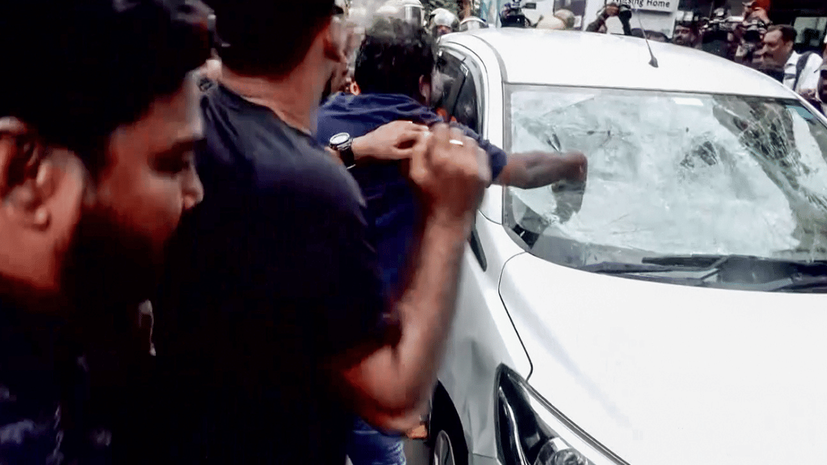 CPI(M) workers attack a vehicle of ED officials in Thiruvananthapuram on Wednesday. | ANI 