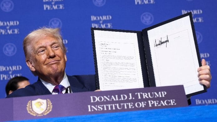 U.S President Donald Trump holds a signed resolution, during the inaugural Board of Peace meeting at the U.S. Institute of Peace in Washington, D.C., U.S., February 19, 2026. | Reuters