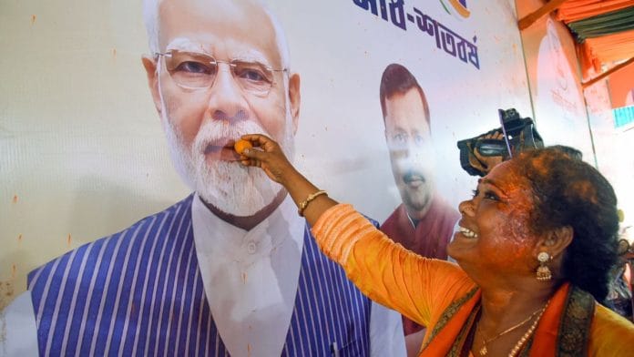 A BJP supporter in Kolkata celebrates the party’s win in Bengal | ANI