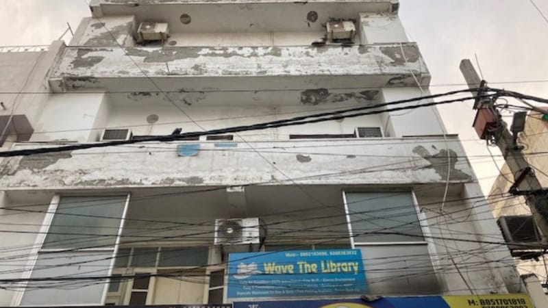 Banner of ’Wave The Library’ suspended from its balcony, details tangled in wires l Photo: Preksha | ThePrint