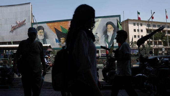 People walk past a mural depicting the late leader of the Islamic Revolution, Ayatollah Ruhollah Khomeini, and the late Iran's Supreme Leader Ayatollah Ali Khamenei, on a street in Tehran, Iran, June 9, 2026. Majid Asgaripour/WANA (West Asia News Agency) via REUTERS