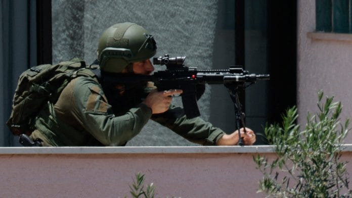 An Israeli soldier looks through the sight of his rifle, at his position near the border with Lebanon, in northern Israel, May 31, 2026. REUTERS/Amir Cohen