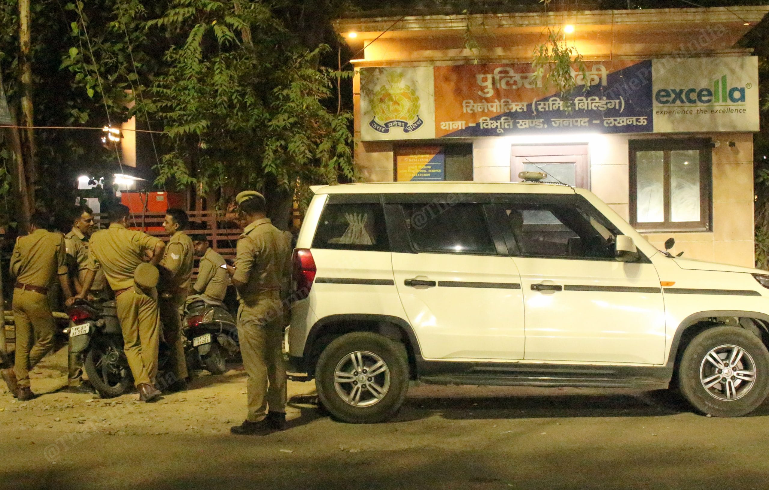 Police personnel standing outside the Summit Building in Lucknow at night