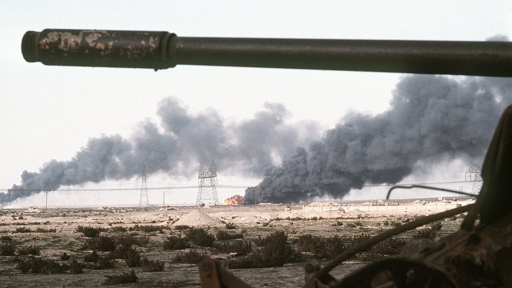 A Kuwaiti oil field set afire by retreating Iraqi troops burns in the distance beyond an abandoned Iraqi tank following Operation Desert Storm | Wikimedia Commons