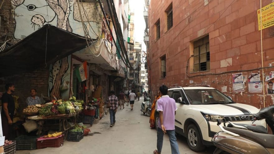 एक आदमी लाल डोरा वाले गांव की तंग गलियों से गुज़रता है | फोटो: अनीशा नेहरा/दिप्रिंट