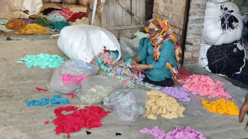 एक महिला पोस्ट-इंडस्ट्रियल टेक्सटाइल कचरे को रंग के आधार पर अलग कर रही है | फोटो: वितस्ता कौल/दिप्रिंट