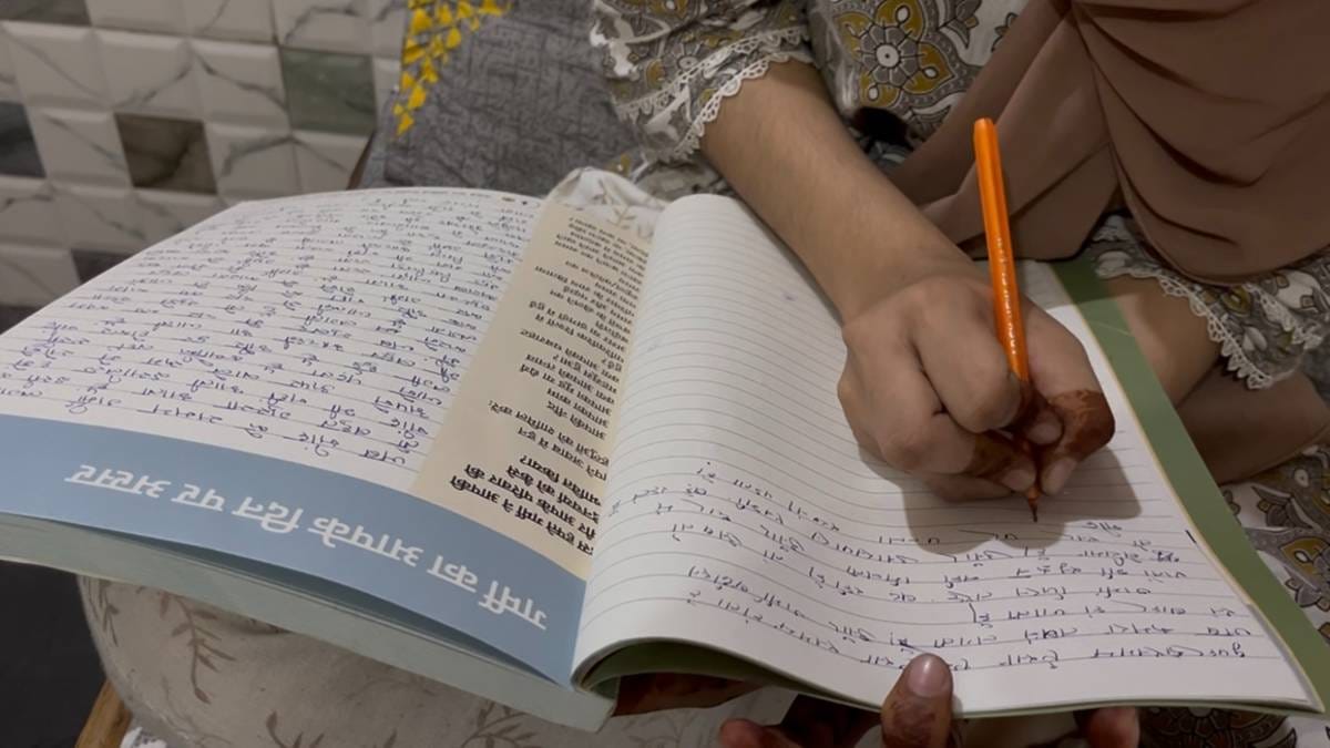 (ऊपर) रेशमा, जो अपने पति और दो बेटियों के साथ एक छोटे से कमरे में रहती हैं और (नीचे) उनकी बेटी गर्मी की डायरी में एंट्री करती हैं | फोटो: स्नेहा रिछारिया/दिप्रिंट