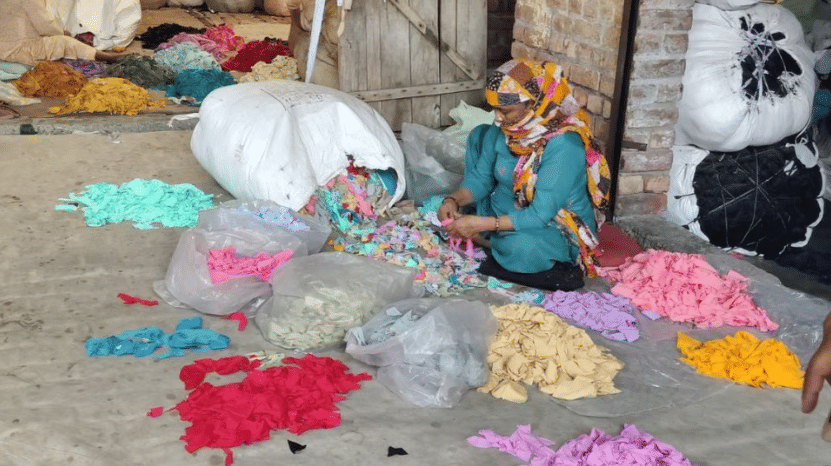 Panipat processes a significant share of the world’s textile waste, and a woman sorts post-industrial textile waste by colour. | Photo: Vitasta Kaul, ThePrint