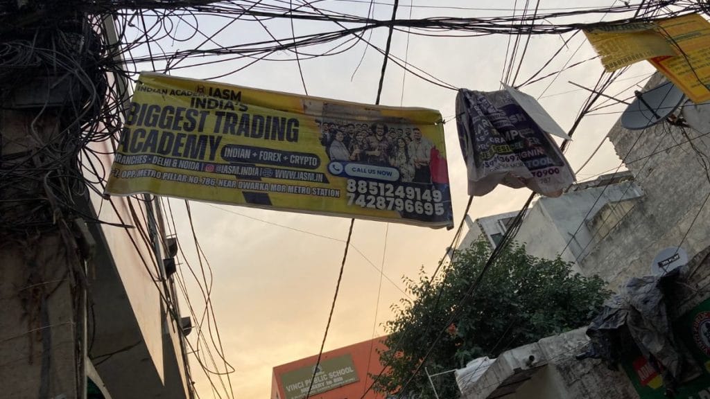 Advertisement of a trading academy tangled in wires in Dwarka Mor, Delhi | Photo: Preksha, ThePrint