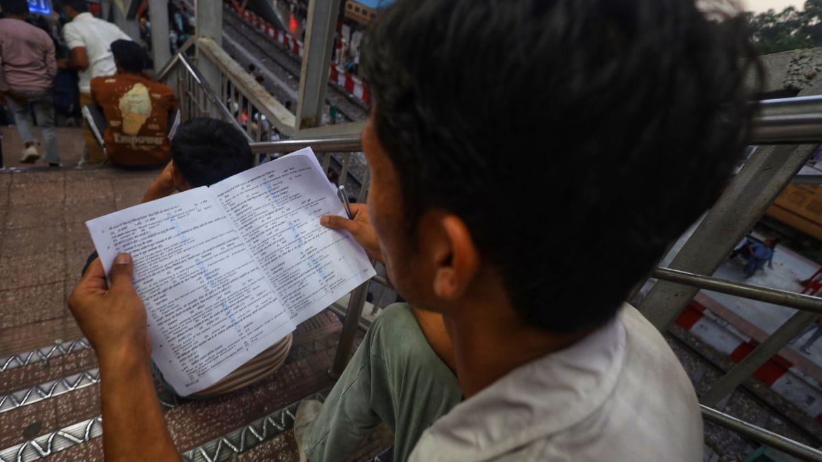An aspirant revises as he waits for the train at the Meerut station. | Manisha Mondal | ThePrint