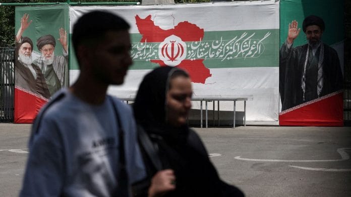 People walk past a banner with pictures of the late leader of the Islamic Revolution, Ayatollah Ruhollah Khomeini, the late Iran's Supreme Leader Ayatollah Ali Khamenei, and Iran's Supreme Leader Mojtaba Khamenei, on a street in Tehran, Iran, June 9, 2026. Majid Asgaripour/WANA (West Asia News Agency) via REUTERS