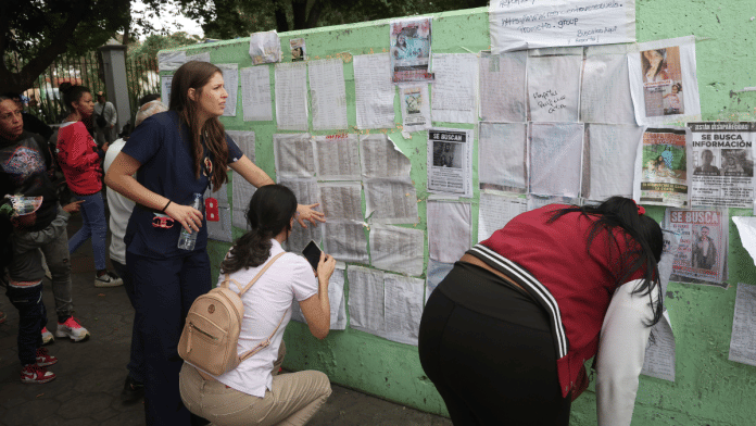 People look at a list of hospitals for the names of their family members in Caracas on June 28 | Bloomberg