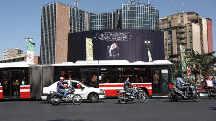 People drive past a billboard with a picture of the late Iran's Supreme Leader Ayatollah Ali Khamenei in Tehran, after US and Iranian officials said they had reached a deal to end their war and reopen the Strait of Hormuz | Majid Asgaripour/WANA via REUTERS