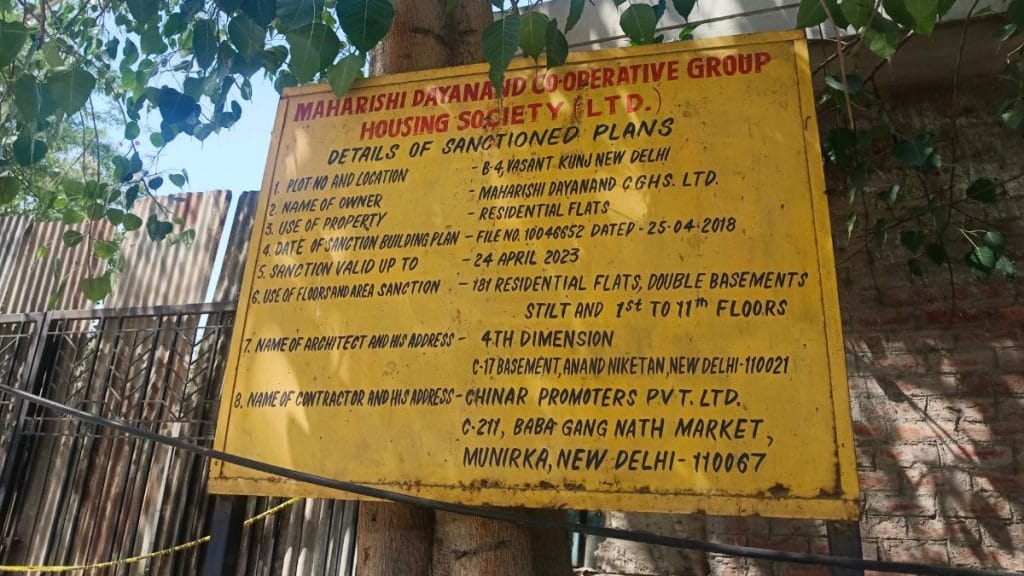 A yellow iron board outside the building displays information related to the housing project. Almina Khatoon | ThePrint