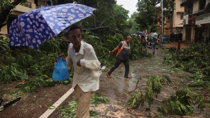 A worker clears fallen trees after heavy rainfall in Mumbai, India Francis Mascarenhas | REUTERS