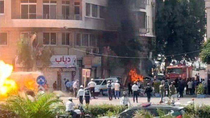 Emergency personnel work as smoke and fire rise at the site where explosive devices blew up near a hotel where French President Emmanuel Macron was meant to be staying, in Damascus, Syria, in this screengrab obtained from a video, July 7, 2026. REUTERS/Yamam Al Shaar