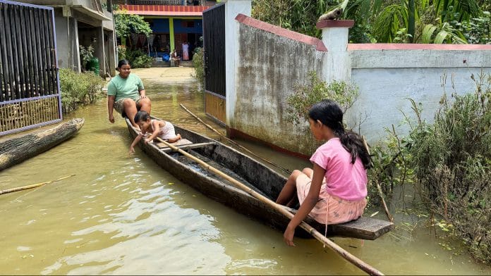 Children use a boat near a residential complex in a flood-affected area, in Sivasagar on Monday. | ANI Photo