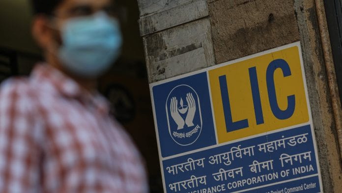 A pedestrian passes a Life Insurance Corp. of India branch office in Mumbai, India. Photographer Dhiraj Singh | Bloomberg