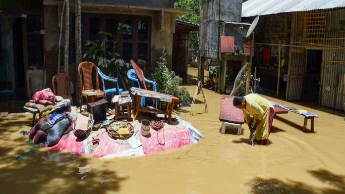 Flood-affected villagers dry their belongings notes in the open after their homes were inundated due to floods, in Jorhat on Tuesday.|ANI