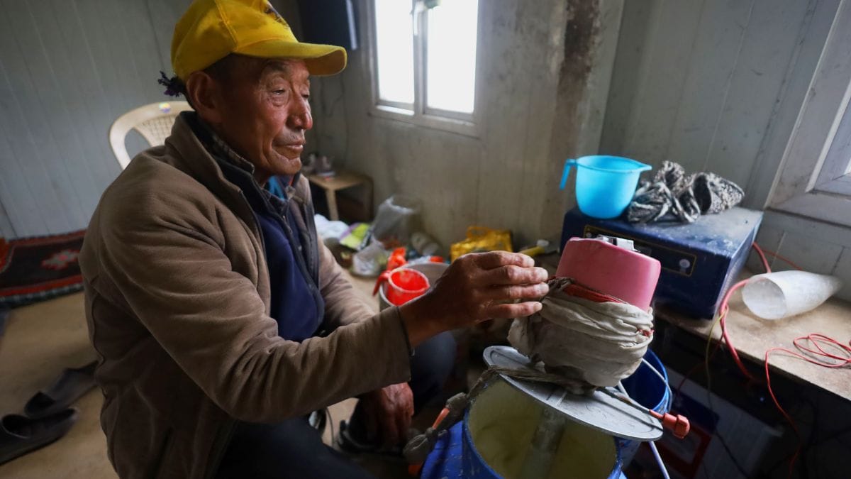 Seventy-three-year-old Tsering Motup, father of Thenlay Nurboo, curns the yak milk at their farm | Manisha Mondal, ThePrint