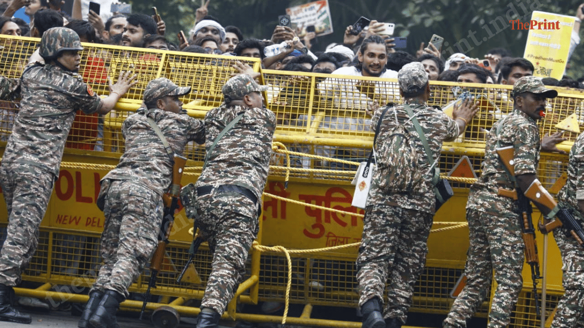 Security personnel try to stop protesters from breaking security barricades near Parliament | Praveen Jain | ThePrint