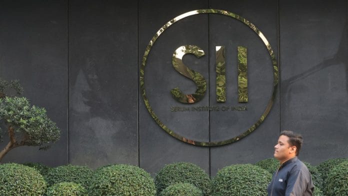Representational | A man walks past logo of Serum Institute of India, at its facility in Pune, on 27 February 2024 | Francis Mascarenhas/Reuters