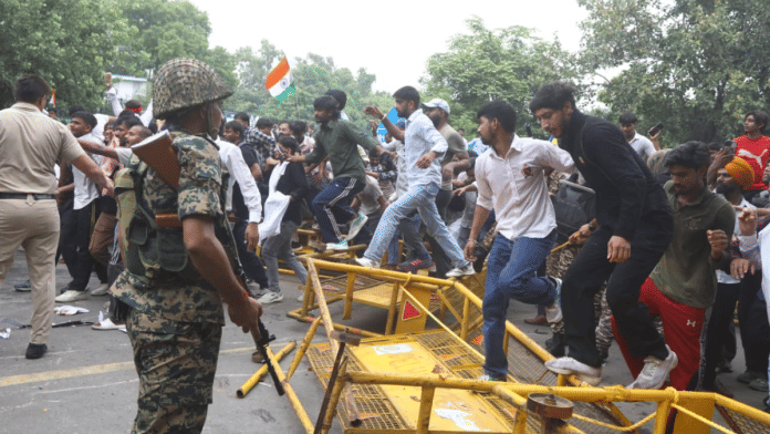 Protesters jump over barricades as they make their way towards Parliament on Monday | Praveen Jain | ThePrint