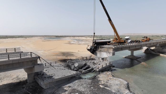 Workers clean up wreckage around a damaged bridge, following US airstrikes carried out a day earlier, in Hormozgan Province. | Bloomberg