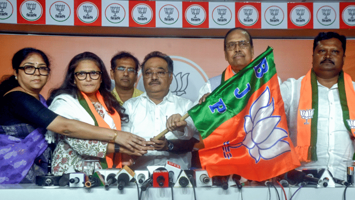 West Bengal BJP President Samik Bhattacharya holds the party's flag as a celebration as former Trinamool Congress MPs Sushmita Dev, Sukhendu Sekhar Roy, and Prakash Chik Baraik join BJP, in Kolkata | ANI