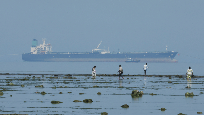 Tourists watch marine life, with the MT Desert Kite oil tanker carrying Russian oil in the background, at Narara Marine National Park in the Arabian Sea, Gujarat, on 11 March 2026. | Reuters