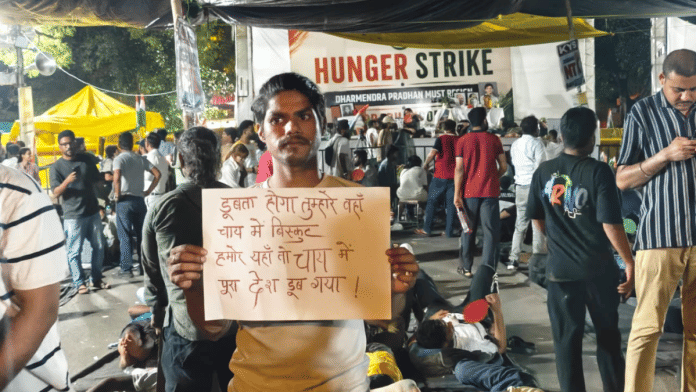 Ravindra Kumar, who works as a cook, shows his poster at New Delhi's Jantar Mantar on Saturday night | Mayank Kumar | ThePrint