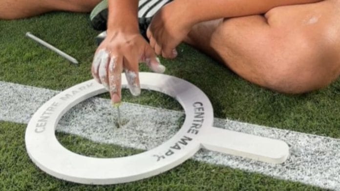 Before any paint is sprayed, the grounds team stretches a string across the pitch to identify the exact centre of the field. A small metal nail, inserted earlier in the week after repeated measurements, marks the precise location Screengrab from FIFA video
