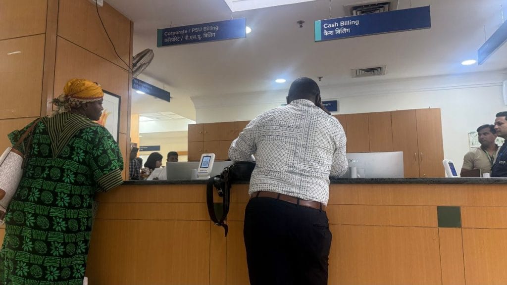 Ben at the hospital billing desk with a patient. Tarini Unnikrishnan | ThePrint