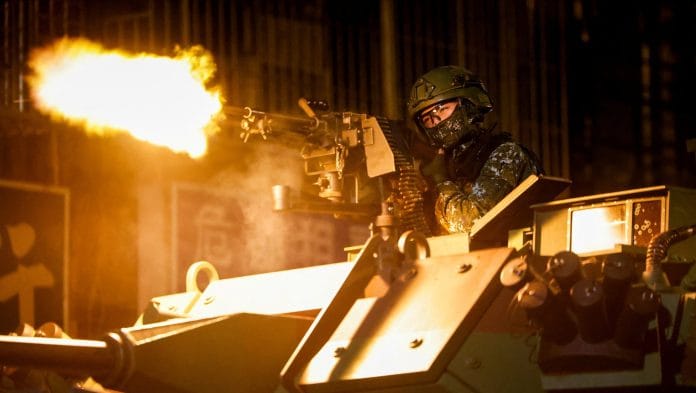 A Taiwanese military member fires ammunition aboard an armoured vehicle during a drill as part of the annual Han Kuang military exercises in Taipei, Taiwan. | Ann Wang/Reuters